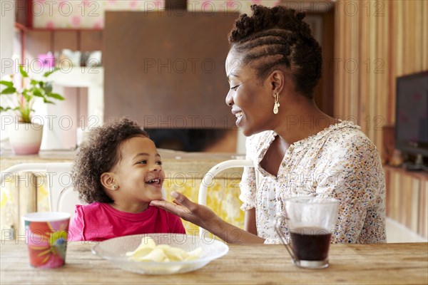 Mother and daughter talking at breakfast table