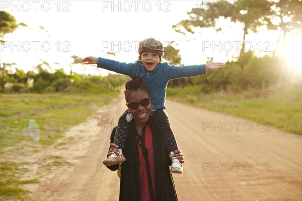 Mother carrying son on shoulders