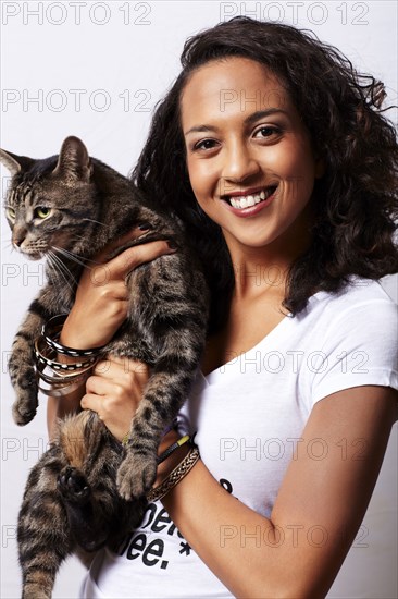 Mixed race woman holding cat