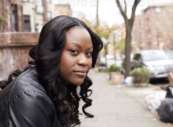 Woman sitting on doorstep on city street