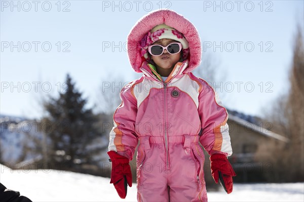 Mixed race girl wearing snowsuit