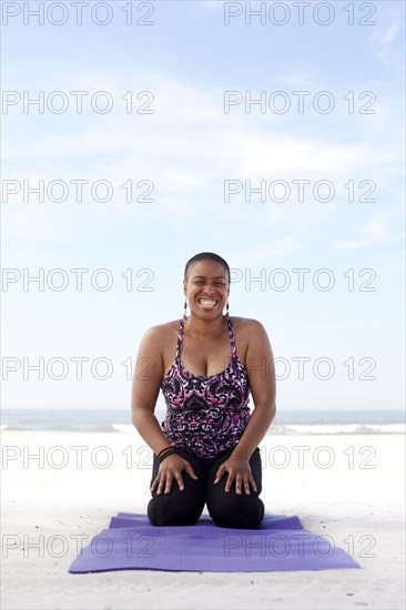 Woman practicing yoga on beach