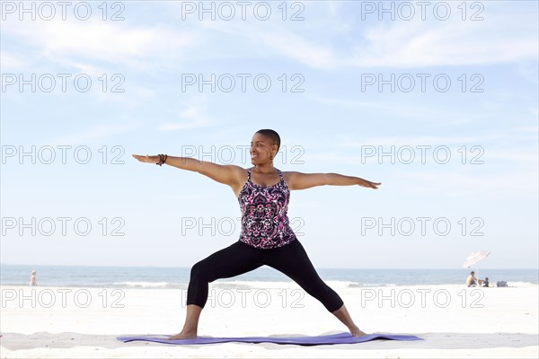 Woman practicing yoga on beach