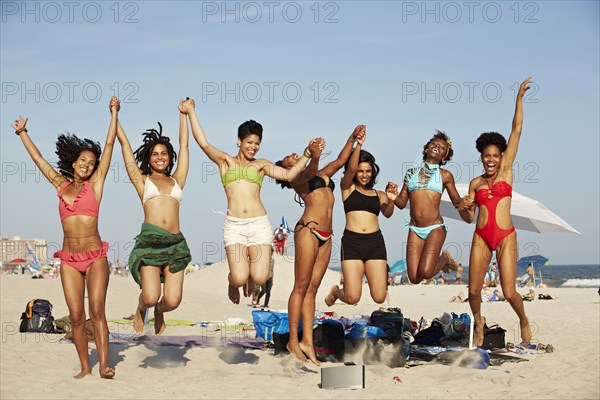 Women jumping for joy on beach