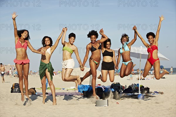 Women jumping for joy on beach