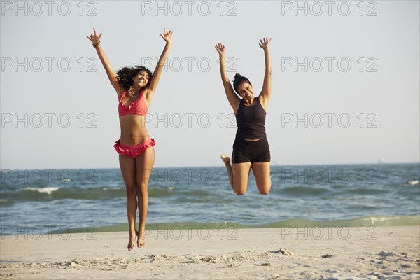 Women jumping for joy on beach