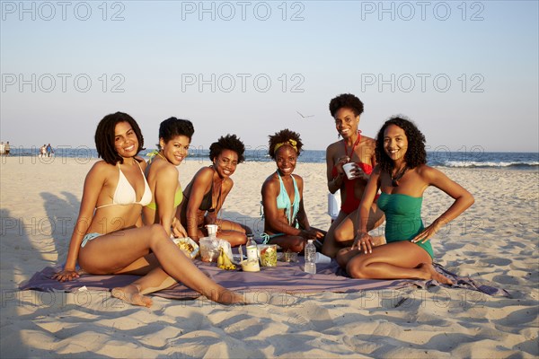 Women relaxing together on beach