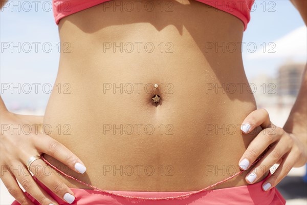 Close up of mixed race woman's pierced bellybutton