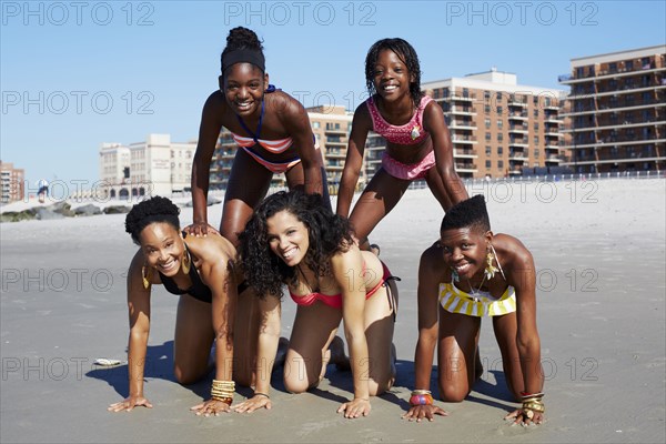 Women forming pyramid on beach