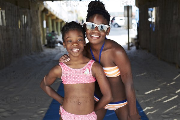 Black girls in bikinis smiling outdoors