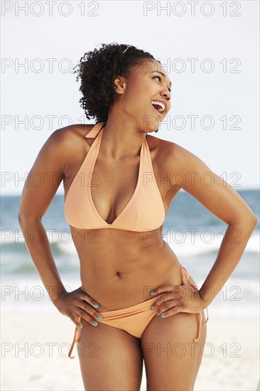 Mixed race woman smiling on beach