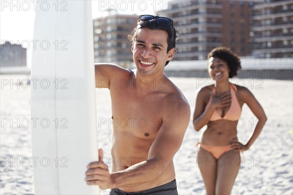 Couple with surfboard on beach