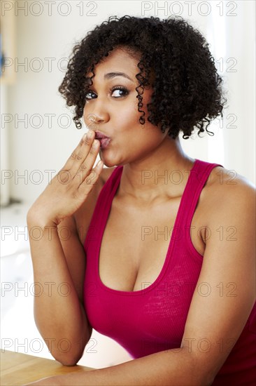 Mixed race woman covering her mouth