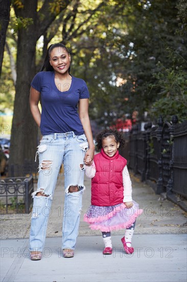 Mother and daughter standing on city street