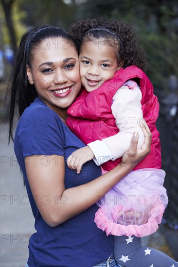 Mother holding daughter outdoors