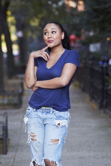 Mixed race woman thinking on urban sidewalk