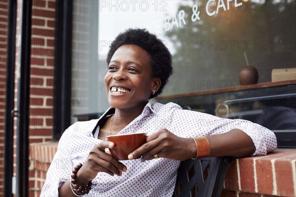 Woman drinking coffee on city street