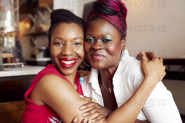 Women hugging in cafe