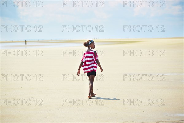 Black girl walking on beach
