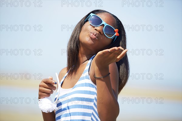 Black teenage girl blowing kisses outdoors