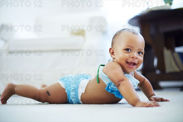 Mixed race girl wearing bikini on living room floor