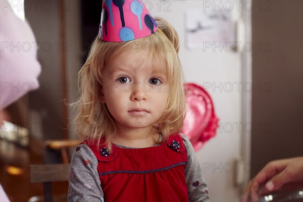 Serious girl wearing party hat