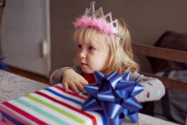 Girl wearing tiara and holding gift