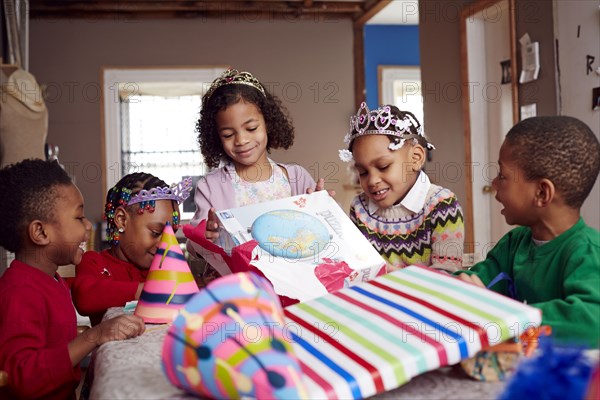 Children wearing tiaras and opening gifts
