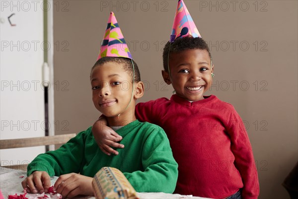 Black boys smiling in party hats