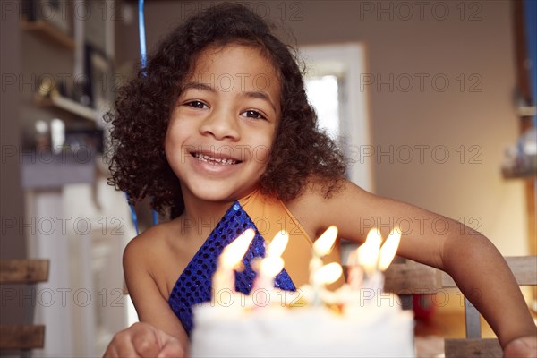 Mixed race girl with cake and candles