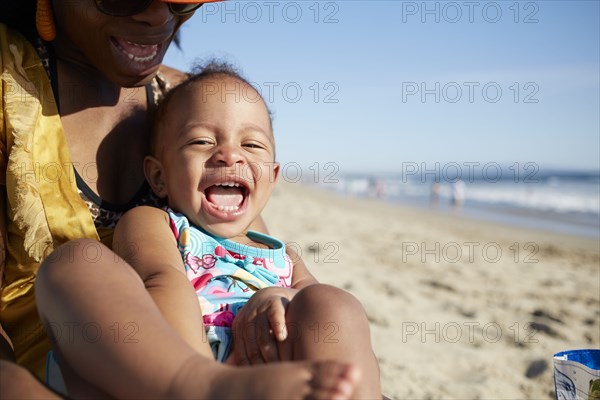Close up of mother and daughter playing on beach