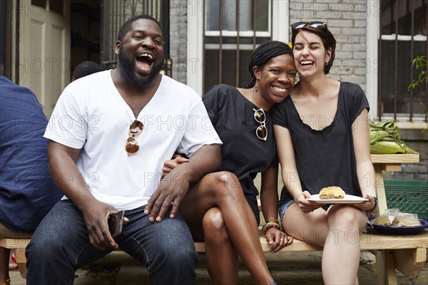 Friends laughing at backyard barbecue