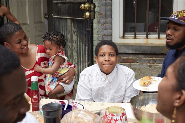 Family eating together at backyard barbecue