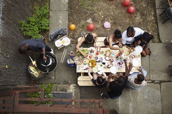 High angle view of friends enjoying backyard barbecue