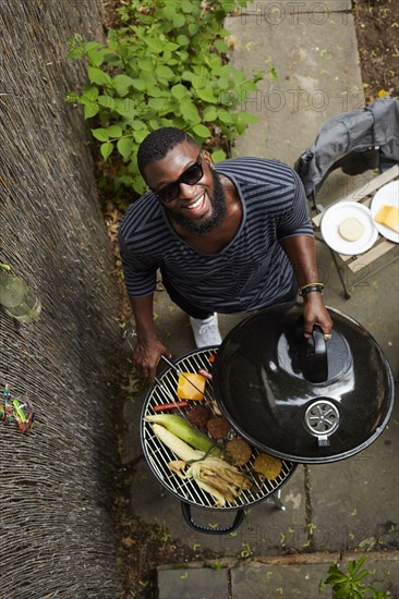 High angle view of African American man grilling at barbecue