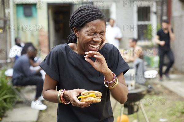 African American woman eating at backyard barbecue