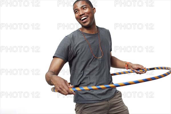 Smiling man playing with plastic hoop