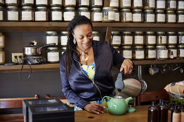 Black woman pouring tea in tea shop