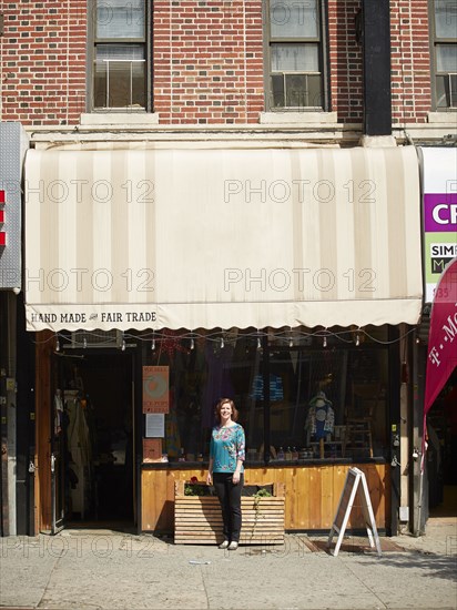 Caucasian woman standing outside store