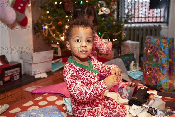 Mixed race boy opening Christmas gifts