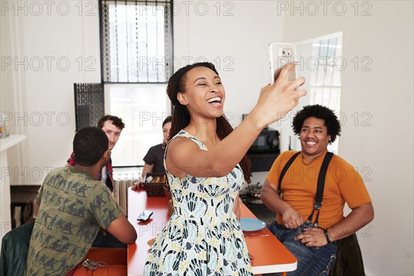 Smiling woman taking selfie with friends