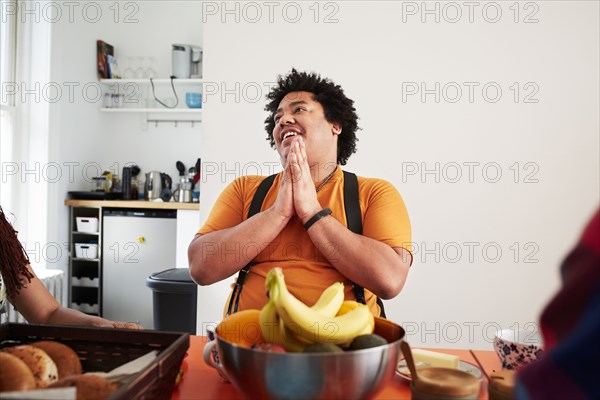 Mixed race man sitting at table and praying