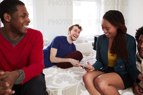 Friends relaxing in bedroom