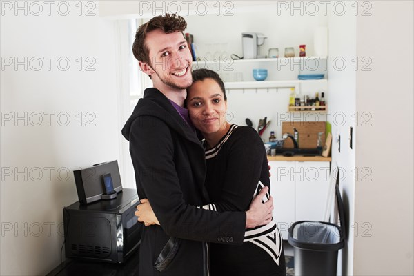 Couple hugging in kitchen