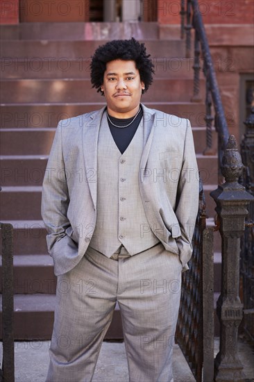 Mixed race man standing near front stoop