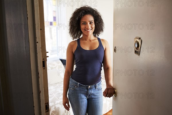 Mixed race woman opening apartment door