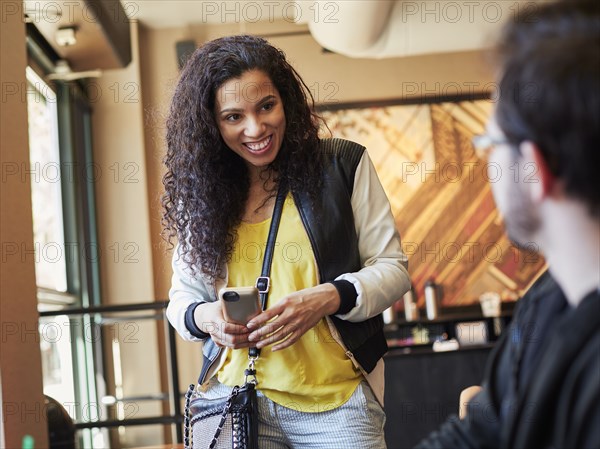 Woman greeting man in cafe