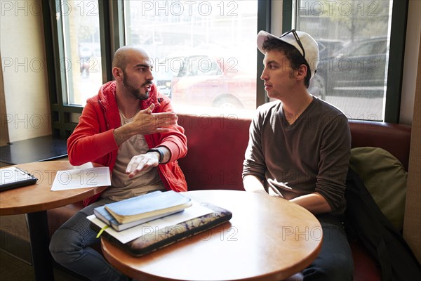 Friends talking in cafe booth