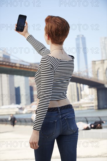 Caucasian woman talking selfie at waterfront