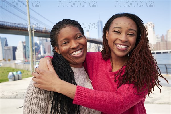 Black women hugging at waterfront